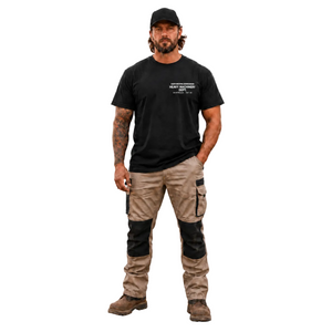 Man wearing a black t-shirt and beige work pants with black accents on a white background