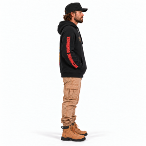 Support Your Local Earthmover VIP Premium Hoodie in black — left sleeve side-profile model mockup, hands in pocket, lettering reads cuff to shoulder